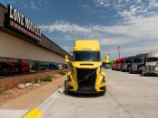 view of front of a yellow 2027 Volvo VNL 860 parked outside Lone Mountain Truck Leasing's Carter Lake, Iowa headquarters