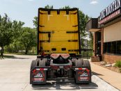 view of back of a yellow 2027 Volvo VNL 860 parked outside Lone Mountain Truck Leasing's Carter Lake, Iowa headquarters