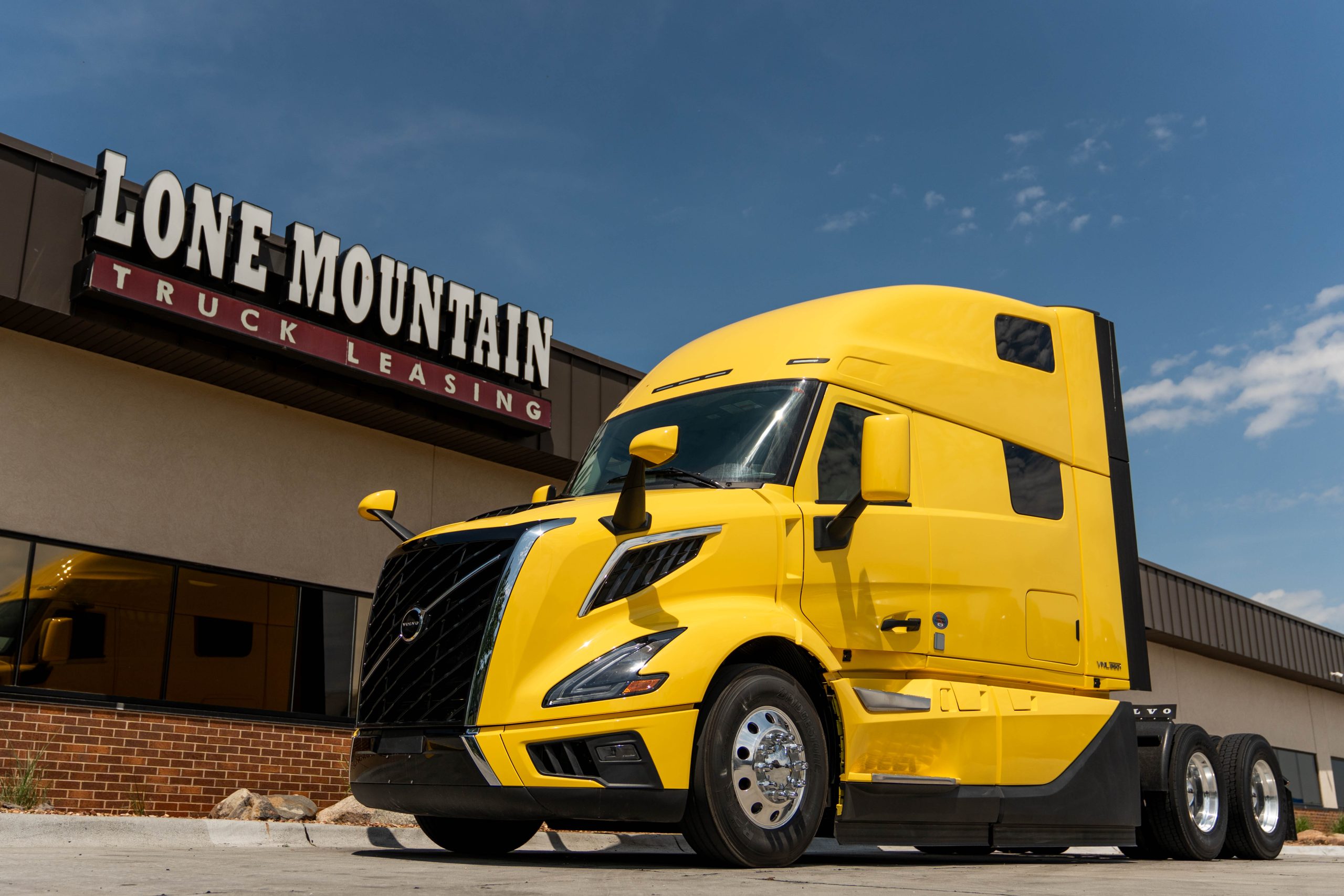 Yellow 2027 Volvo VNL 860 parked outside the Lone Mountain Truck Leasing headquarters in Carter Lake, Iowa