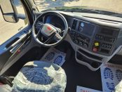 Driver side with steering wheel and dash inside a 2022 Black Peterbilt 579