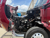 Hood of a maroon 2022 Kenworth T680 up with engine visible
