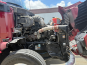 Hood of a maroon 2022 Kenworth T680 up with engine visible