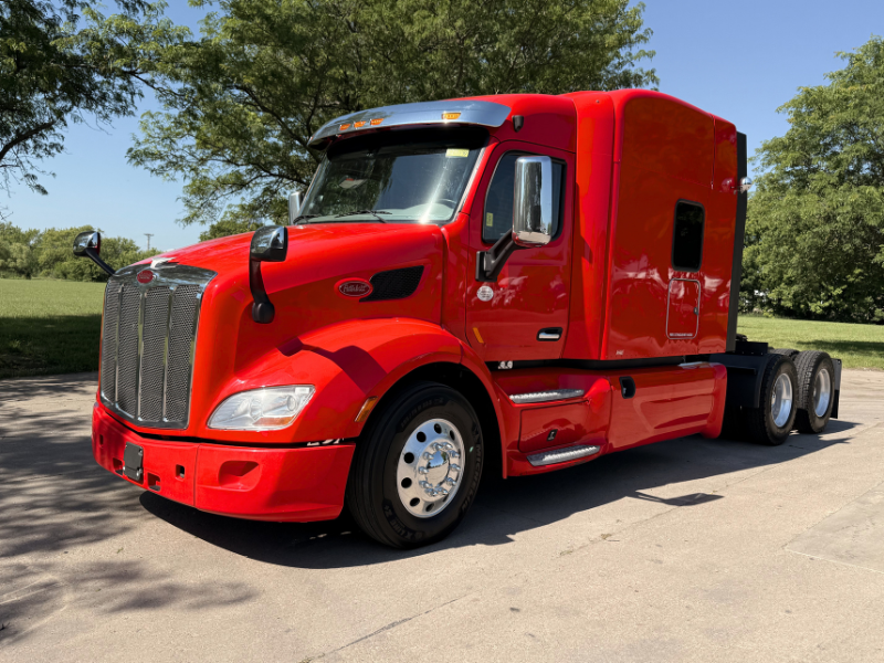 Driver side and front of a red 2022 Peterbilt 579 mid-roof