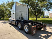 Driver side and rear of a white 2022 Peterbilt 579