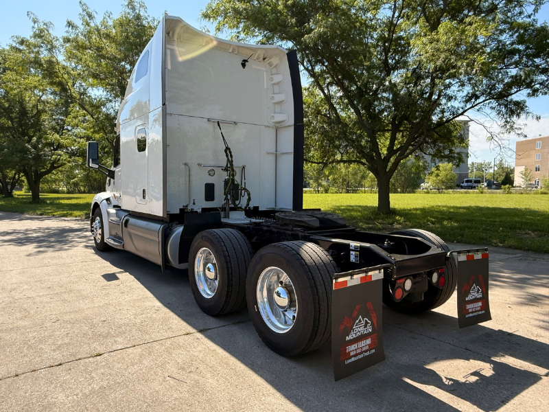 Driver side and rear of a white 2022 Peterbilt 579