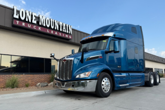 Blue 2023 Peterbilt 579 parked outside Lone Mountain Truck Leasing in Carter Lake, Iowa
