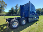 Passenger side rear of a blue 2022 Freightliner Cascadia