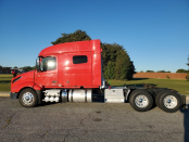 Driver's side exterior of a red 2023 Volvo VNL 740