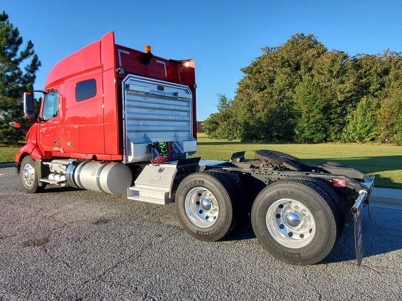 Driver's side and rear view of the exterior of a red 2023 Volvo VNL 740