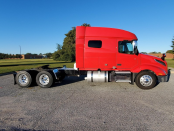 Passenger's side view of exterior of a red 2023 Volvo VNL 740